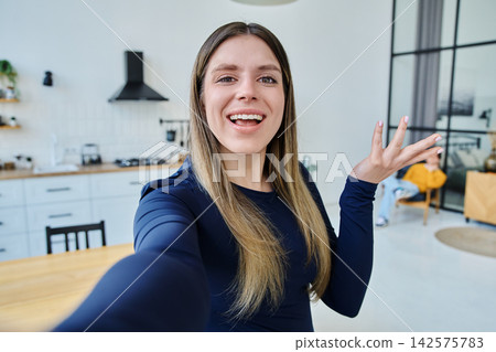 Selfie portrait happy beautiful young woman in home interior 142575783