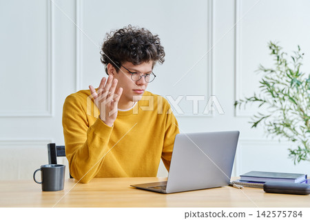 Young man freelancer or student using laptop for video call, at home office Young man freelancer or student using laptop for video call, at home office 142575784