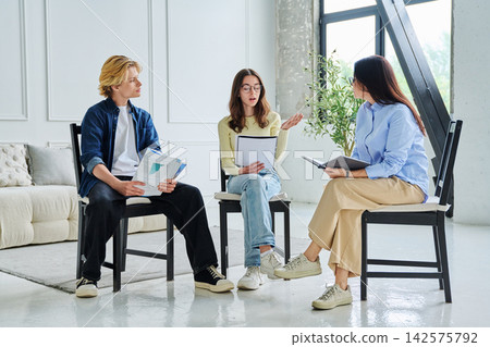 Young students talking to female counselor at office 142575792