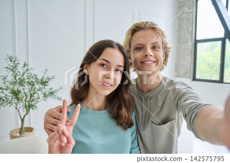 Happy teen friends taking selfie showing peace sign Happy teen friends taking selfie showing peace sign 142575795