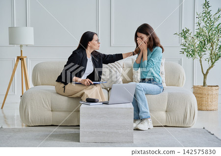 Therapist comforting crying young woman in office Therapist comforting crying young woman in office 142575830