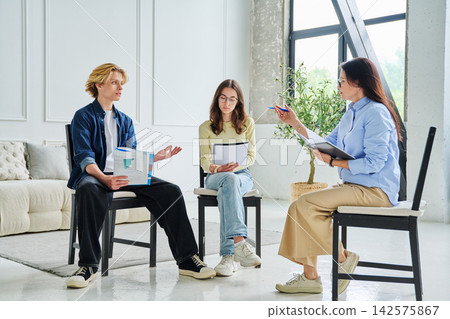 Young people listening to tutor at group therapy Young people listening to tutor at group therapy 142575867