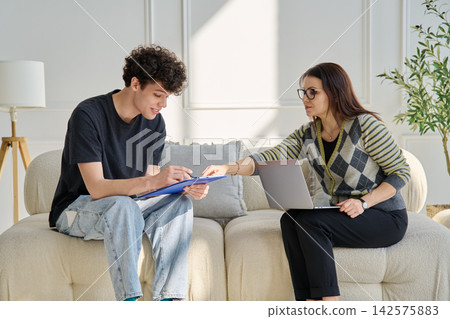 Young male patient in therapy session talking with female psychotherapist Young male patient in therapy session talking with female psychotherapist 142575883