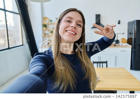 Selfie portrait happy beautiful young woman in home interior Selfie portrait happy beautiful young woman in home interior 142575897