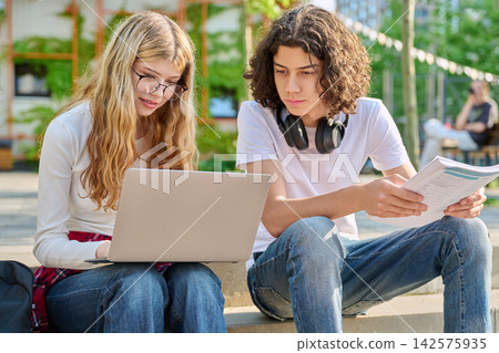 Focused teenage students studying with laptop on campus Focused teenage students studying with laptop on campus 142575935