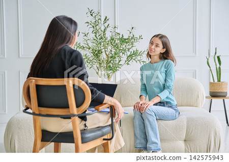 Teenage girl listening to psychologist in the office Teenage girl listening to psychologist in the office 142575943