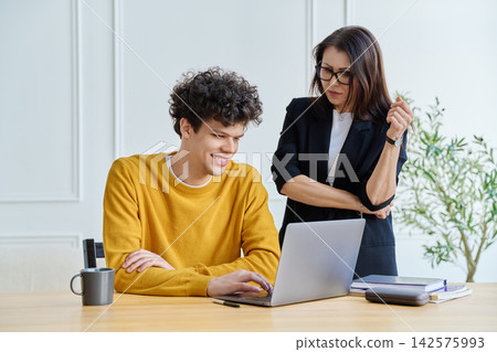 Confident female mentor teacher advising teaching male university student Confident female mentor teacher advising teaching male university student 142575993