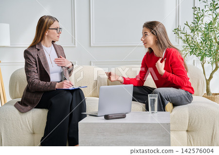 Teenage girl patient in therapy session with social mental therapist 142576004