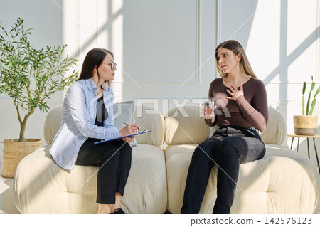 Young woman patient talking with female psychologist, mental counselor Young woman patient talking with female psychologist, mental counselor 142576123