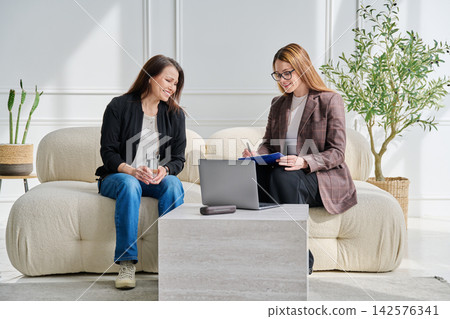 Professional female psychologist or HR manager consulting middle-aged woman in office Professional female psychologist or HR manager consulting middle-aged woman in office 142576341