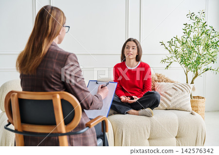 Teenage girl patient in therapy session with social mental therapist Teenage girl patient in therapy session with social mental therapist 142576342