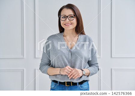 Portrait of charming middle-aged woman in glasses and a grey cardigan 142576366