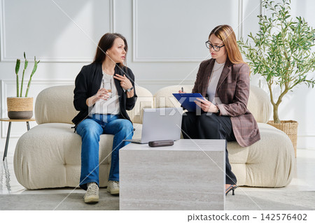Sad mature woman in therapy with a psychologist Sad mature woman in therapy with a psychologist 142576402
