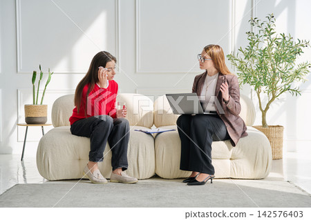 Sad teenage female patient in therapy session in psychologist office Sad teenage female patient in therapy session in psychologist office 142576403