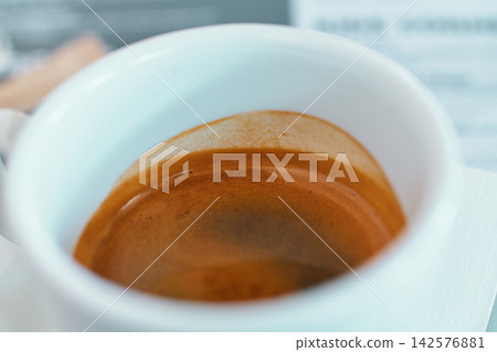 Close-up view of freshly brewed espresso coffee with rich crema inside white ceramic cup. Close-up view of freshly brewed espresso coffee with rich crema inside white ceramic cup. 142576881