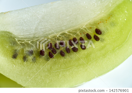 Macro close-up view of fresh green kiwi fruit flesh and tiny dark seeds Macro close-up view of fresh green kiwi fruit flesh and tiny dark seeds 142576901