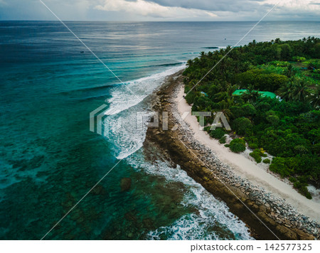 Drone view of sea with waves and coastline on Fuvahmulah island in Maldives Drone view of sea with waves and coastline on Fuvahmulah island in Maldives 142577325