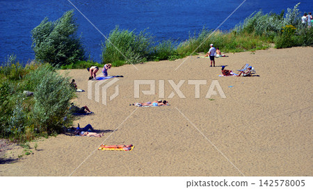 Warsaw, Poland. 15 August 2026. Stadium Beach (or Poniatowka beach) in the vicinity of the National Stadium. People sunbathe on the sandy beach. Warsaw, Poland. 15 August 2026. Stadium Beach (or Poniatowka beach) in the vicinity of the National Stadium. People sunbathe on the sandy beach. 142578005