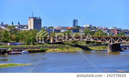 Warsaw, Poland. 15 August 2026. Railway bridge over the Vistula river. View of the center of Warsaw with tall office buildings. Warsaw, Poland. 15 August 2026. Railway bridge over the Vistula river. View of the center of Warsaw with tall office buildings. 142578028