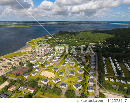 High angle wide horizontal aerial drone photograph of lakeside holiday park resort, solar chalets, water park, campsite, and Lake Veere in Kamperland, Zeeland, Netherlands on sunny summer day High angle wide horizontal aerial drone photograph of lakeside holiday park resort, solar chalets, water park, campsite, and Lake Veere in Kamperland, Zeeland, Netherlands on sunny summer day 142578347