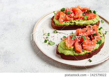 breakfast, Sandwiches with smoked salmon and avocado, on dark rye bread, with microgreens, on a marble table, homemade, no people, breakfast, Sandwiches with smoked salmon and avocado, on dark rye bread, with microgreens, on a marble table, homemade, no people, 142579022