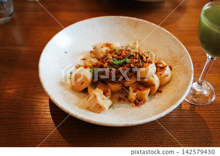 dumplings and green drink smoothie served at a restaurant on the side during lunch dumplings and green drink smoothie served at a restaurant on the side during lunch 142579430