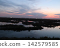 Venetian Lagoon sunset with pink clouds and water reflection 142579585