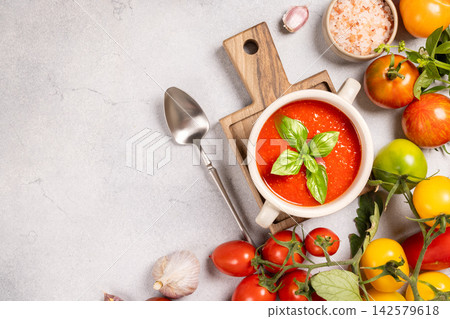Fresh tomato soup bowl with basil and ingredients Fresh tomato soup bowl with basil and ingredients 142579618