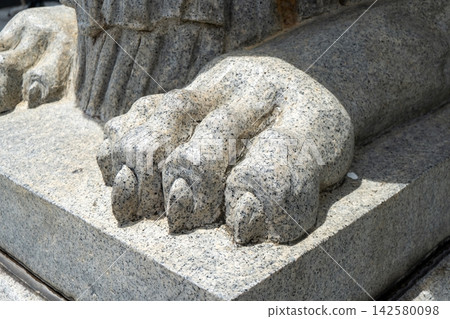 Stone lion paw sculpture in bright sunlight outdoors Stone lion paw sculpture in bright sunlight outdoors 142580098