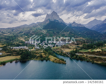 Tena Valley and Foratata Under Evening Clouds. Aerial view of the Tena Valley with villages, the reservoir and the iconic Pena Foratata peak under dramatic evening clouds in the Spanish Pyrenees, Arag Tena Valley and Foratata Under Evening Clouds. Aerial view of the Tena Valley with villages, the reservoir and the iconic Pena Foratata peak under dramatic evening clouds in the Spanish Pyrenees, Arag 142580161