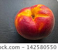 Ripe Peach Sitting on a Black Surface Ready to Be Enjoyed 142580550
