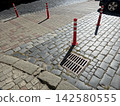 Bright Red Road Signal Posts Marking the Pavement in an Urban Area 142580555