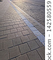 Road Markings on a City Sidewalk Create a Vibrant Urban Scene 142580559