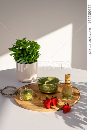 Artistic Matcha Still Life with Sunbeam and Plant Shadows. Elegant matcha still life arrangement with ceramic bowl and bamboo tools illuminated by angular sunbeam with plant shadows. Contemplative Artistic Matcha Still Life with Sunbeam and Plant Shadows. Elegant matcha still life arrangement with ceramic bowl and bamboo tools illuminated by angular sunbeam with plant shadows. Contemplative 142580623