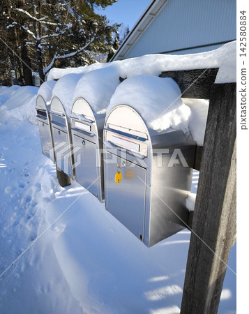 Mailboxes under a thick layer of snow in winter. 142580884
