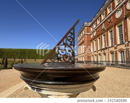 Antique stone sundial in the formal gardens of Hampton Court Palace, England 142580896