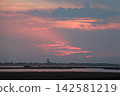 Venetian Lagoon sunset with pink clouds and water reflection 142581219