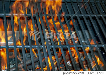 Intense Open Flame Beneath Barbecue Grill Grate Outdoors Intense Open Flame Beneath Barbecue Grill Grate Outdoors 142581770