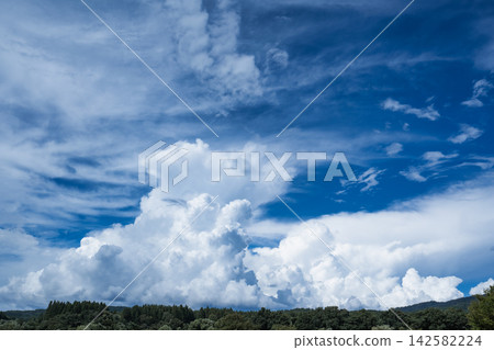 一朵巨大的積雨雲升騰在夏日的山脈之上，映襯著湛藍的天空。 142582224