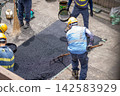 Asphalt paving, paving work, asphalt mixture spreading and leveling, paving rake, surface work, surface finishing with a sieve to ensure uniform particle size. 142583929