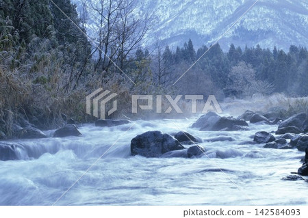 山腳下,冬日寧靜的景色盡收眼底,一條小河從融化的雪水中潺潺流淌。 山腳下,冬日寧靜的景色盡收眼底,一條小河從融化的雪水中潺潺流淌。 142584093