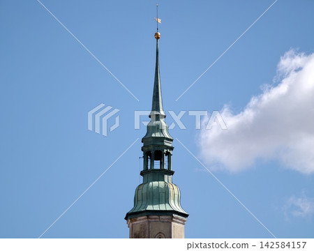 Travel and architecture imagery showcasing slender green copper steeple against expansive sky Travel and architecture imagery showcasing slender green copper steeple against expansive sky 142584157