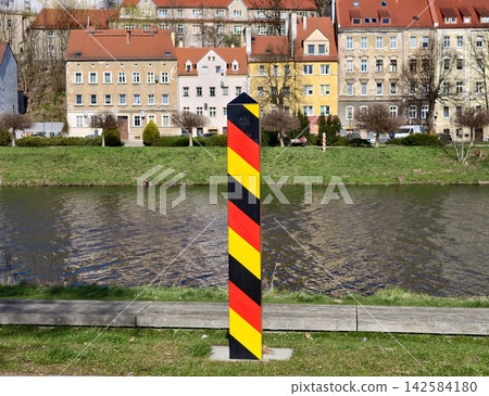 Colorful houses along peaceful river. Tranquil water reflecting surrounding houses and cloudy sky Colorful houses along peaceful river. Tranquil water reflecting surrounding houses and cloudy sky 142584180