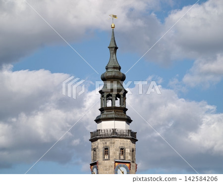 Victorian era clock tower adorned with ornate cornices and gilded weather vane against stormy skies Victorian era clock tower adorned with ornate cornices and gilded weather vane against stormy skies 142584206