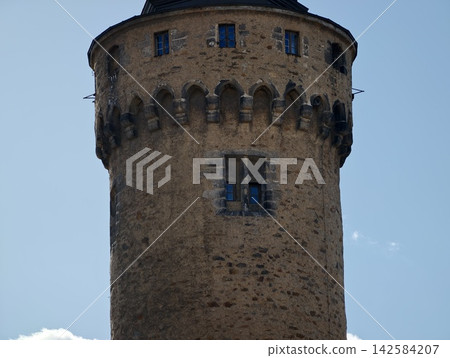 Detailed view of ancient cylindrical stone tower showcasing battlements and weathered masonry surfaces Detailed view of ancient cylindrical stone tower showcasing battlements and weathered masonry surfaces 142584207
