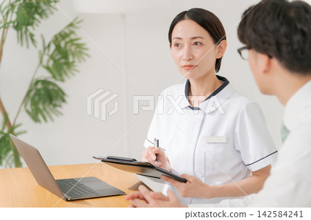 診所的女工作人員和一名男病人 診所的女工作人員和一名男病人 142584241