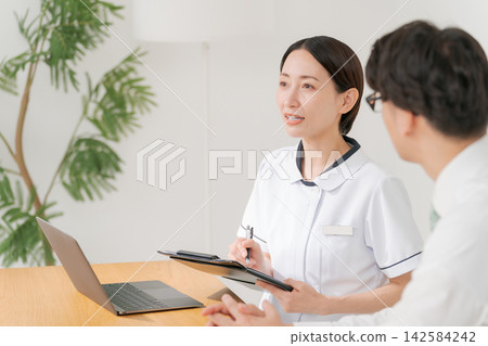 診所的女工作人員和一名男病人 診所的女工作人員和一名男病人 142584242