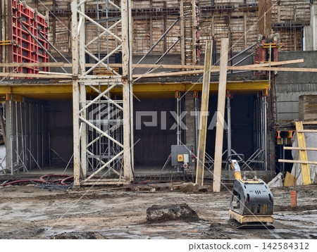 Overview of building project progress. Visual representation of foundation work and crane operation Overview of building project progress. Visual representation of foundation work and crane operation 142584312