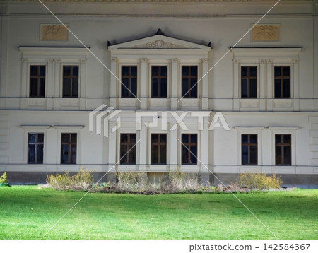 Classical mansion with symmetrical features. Historic neoclassical house with manicured surroundings Classical mansion with symmetrical features. Historic neoclassical house with manicured surroundings 142584367