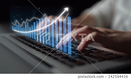 Hands typing on laptop keyboard with digital graph overlay representing growth, finance trends, technology, and data analysis in modern workspace Copula 142584416